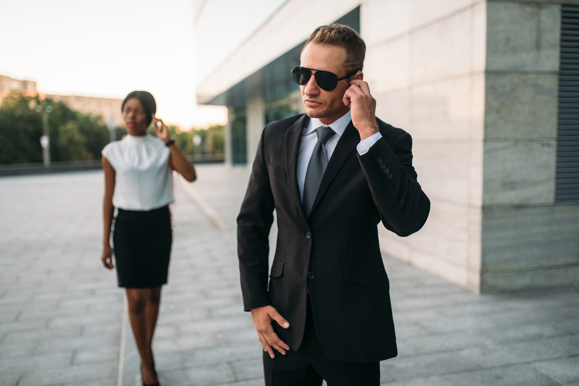 bodyguard in sunglasses and black business woman